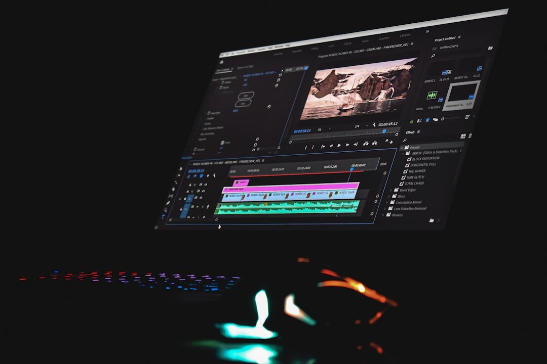 Video editor working at a multi-monitor editing suite with a colour timeline on screen